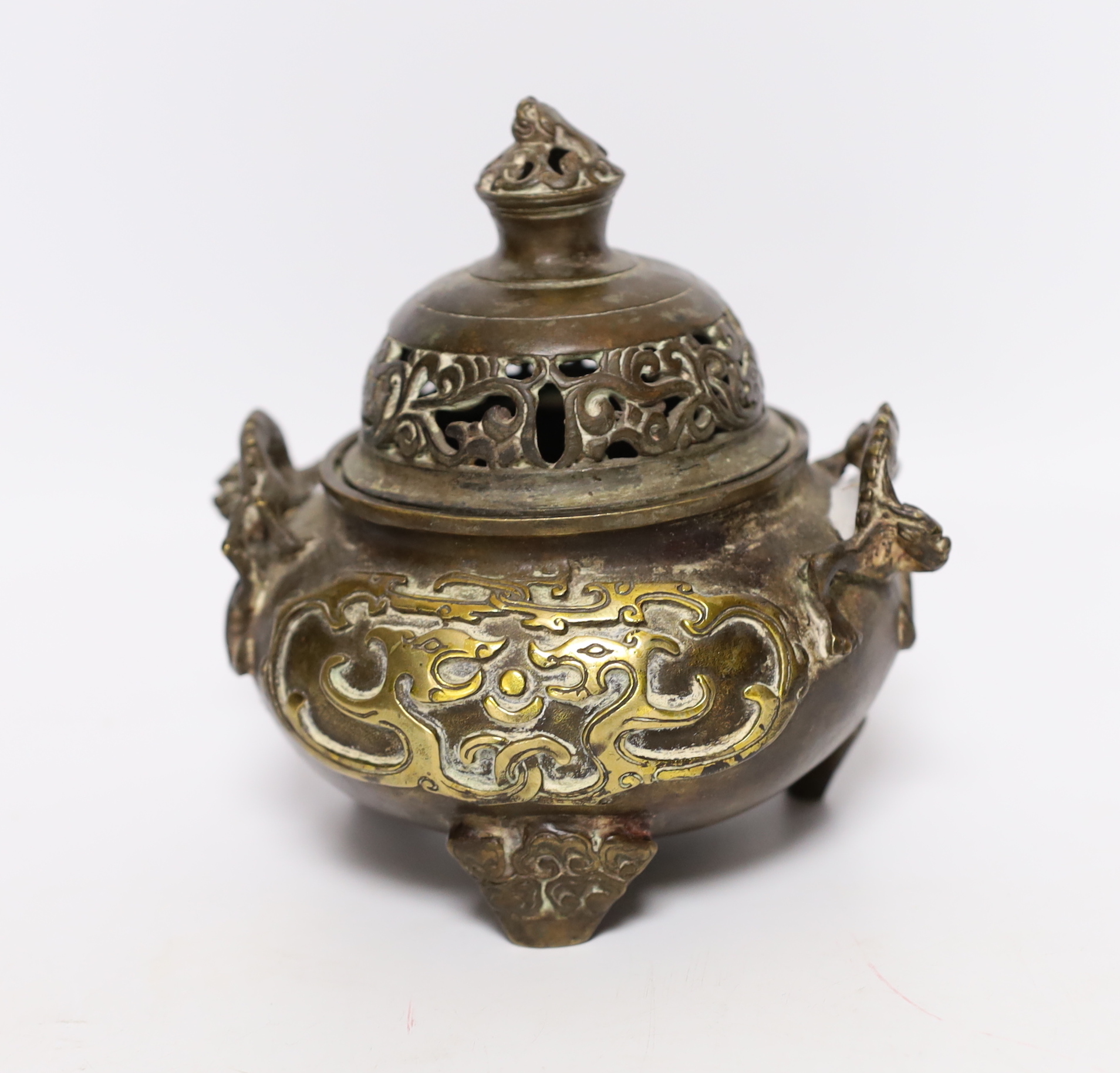 A Chinese parcel gilt bronze censer, with pierced lid and twin zoomorphic handles, 15cm high